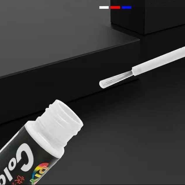 A close-up of a glossy black bottle with a white brush applicator shown against a dark black background. 