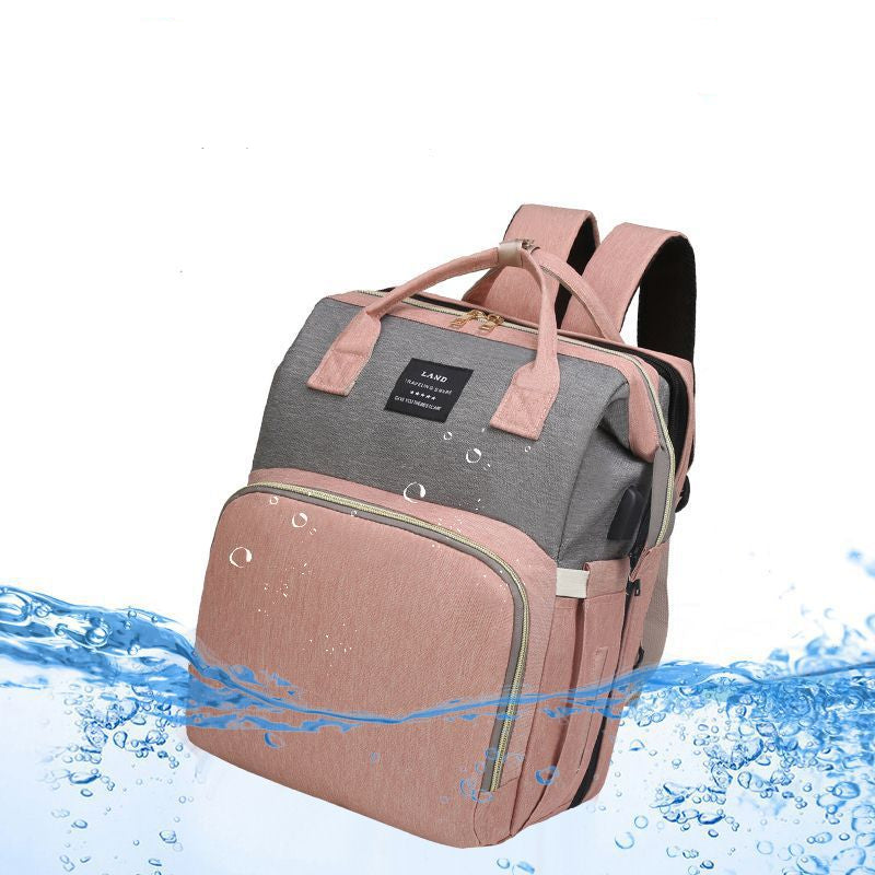 A pink and gray backpack with dual top handles and a front zippered pocket, shown with water-splash graphics.